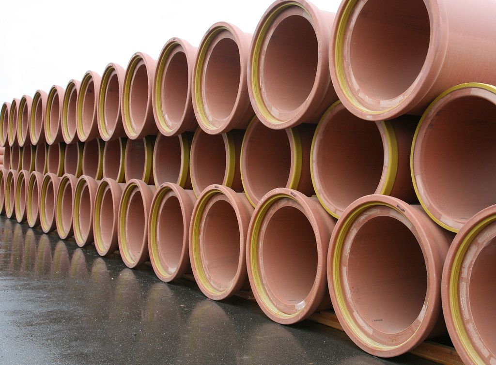 Stacked clay sewer pipes ready for installation in Cerritos